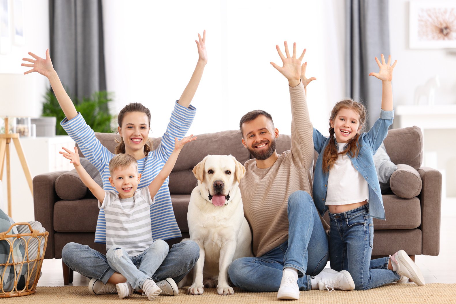 Joyful family with kids and dog having fun at home