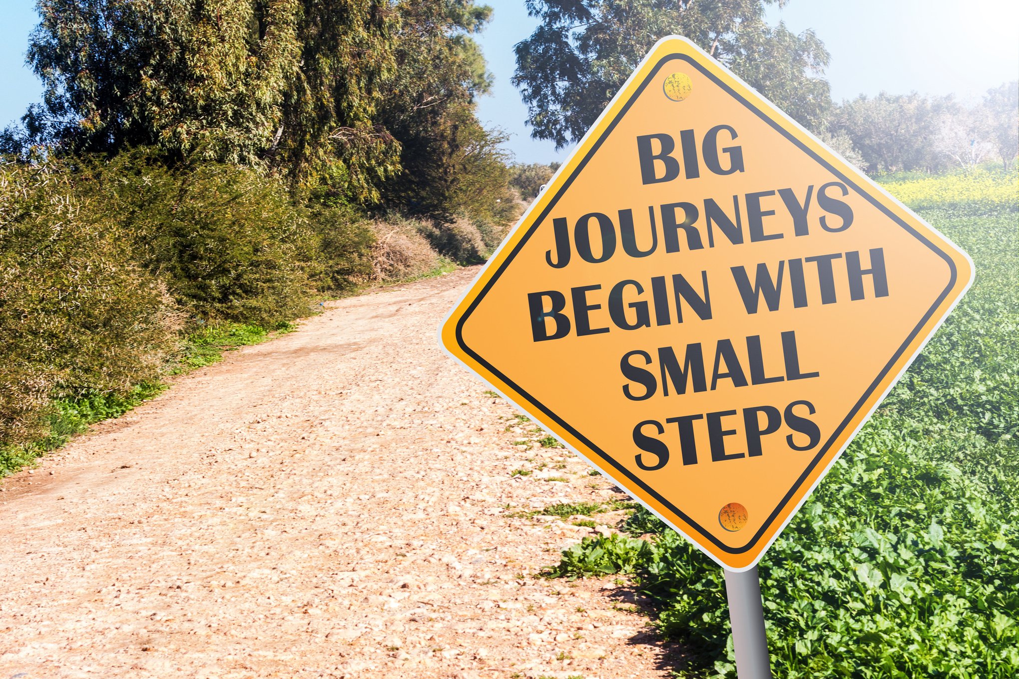 Big Journeys Begin With Small Steps sign on road